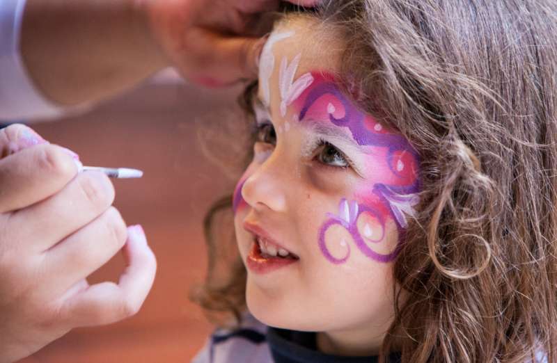 Little girl getting face painting.